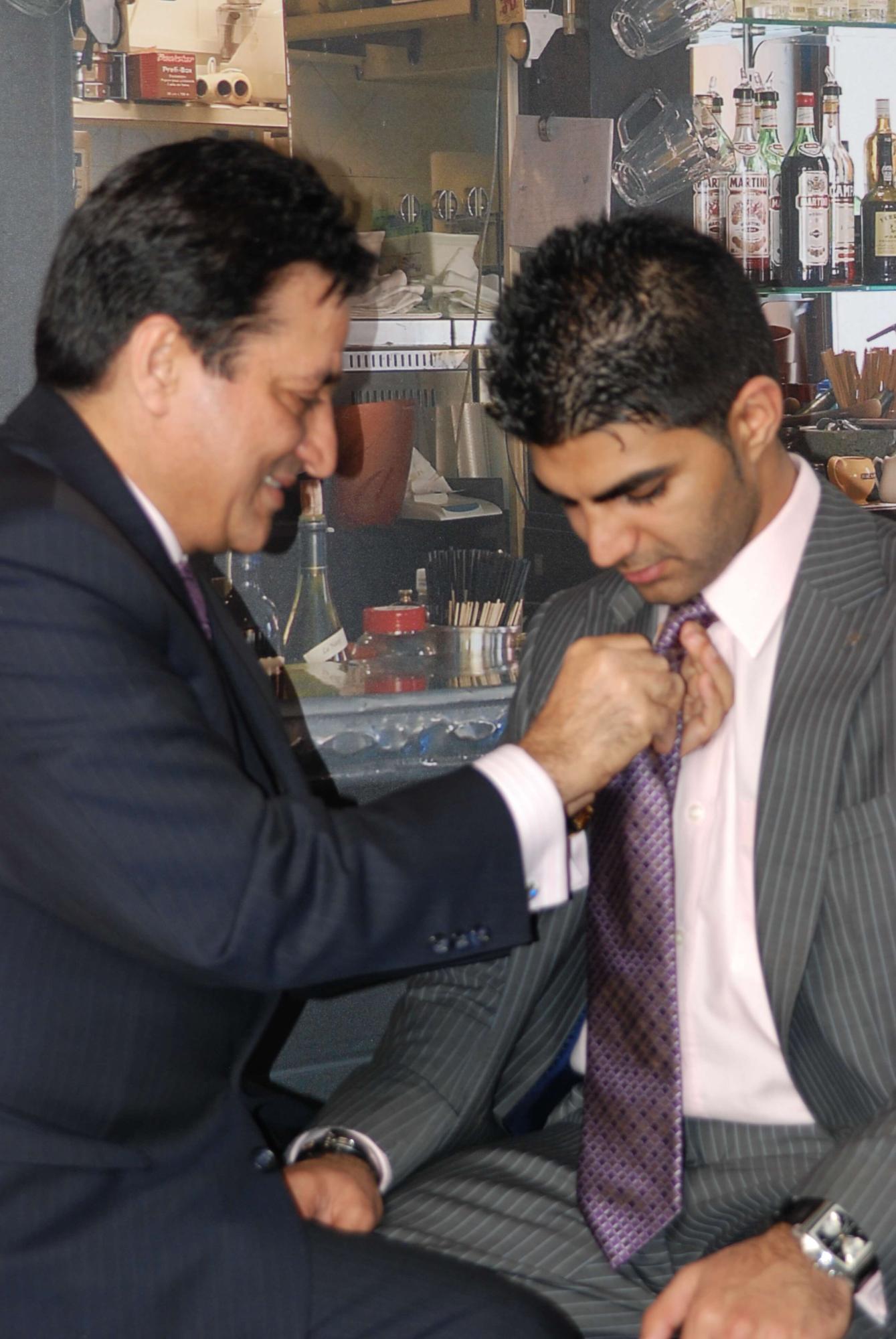 Love Mahtani is tying a tie node for Rish Mahtani