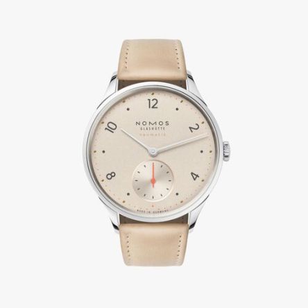 Nomos Minimatik Champagne Ref. 1204 featuring a champagne-colored dial, neon orange minute markers, and a beige cowhide strap.