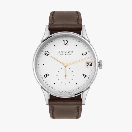The Nomos Minimatik 39 Date Gold Ref. 1251 features a silver-plated dial with gold-colored hands and a golden date window.