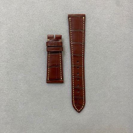 Patinated brown matte alligator strap with peach stitching, square scales, deployment clasp, short length